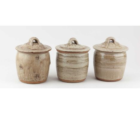 JIM MALONE (born 1946); a trio of stoneware jars and covers covered in green ash glaze with combed and impressed decoration, 