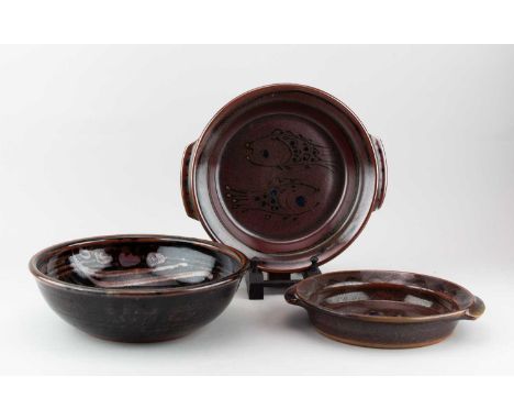 Winchcombe Pottery; a stoneware bowl covered in tenmoku breaking to kaki glaze with wax resist decoration, impressed pottery 