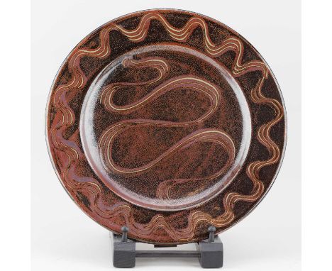 † RAY FINCH (1914-2012) for Winchcombe Pottery; a stoneware charger covered in tenmoku breaking to kaki glaze with meander de