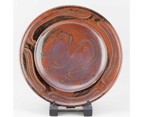 † RAY FINCH (1914-2012) for Winchcombe Pottery; a stoneware charger covered in tenmoku breaking to kaki glaze with meander de