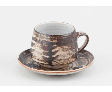 Briglin Pottery; a tin glazed earthenware cup and saucer, impressed pottery marks, cup height 8cm, saucer diamedter 15.5cm.  