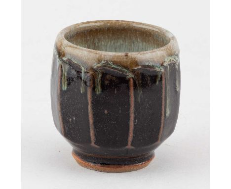 † MIKE DODD (born 1943); a cut sided stoneware yunomi covered in tenmoku breaking to kaki glaze with running nuka rim, impres