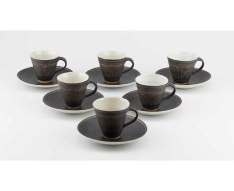 † LUCIE RIE (1902-1995); a set of six stoneware cups and saucers partially covered in manganese glaze with sgraffito decorati