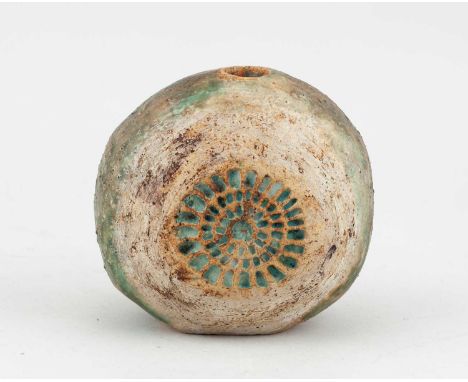 † ALAN WALLWORK (1931-2019); a stoneware pebble form partially covered in green glaze with iron staining and impressed decora