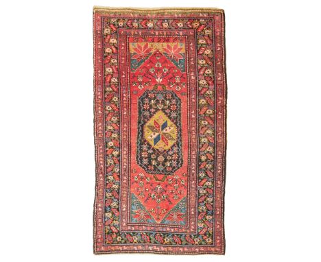 KARABAGH CARPET SOUTH CAUCASUS, POSSIBLY WOVEN WITH DATE 1928 the red field with elongated brown and olive-green medallion, g