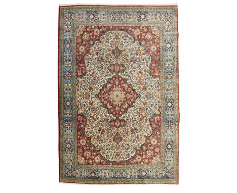 QUM CARPET CENTRAL PERSIA, MID/LATE 20TH CENTURY the cream field with red medallion, similar spandrels, within light blue bor