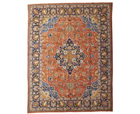 TABRIZ CARPET NORTHWEST PERSIA, MID 20TH CENTURY the brick red field with indigo medallion, blue spandrels, within indigo bor