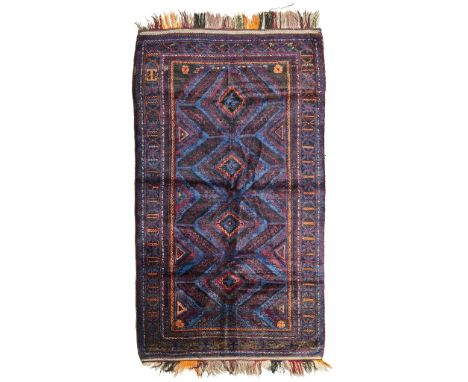 BELOUCH CARPET NORTHEAST PERSIA, EARLY/MID 20TH CENTURY the dark indigo field with column of four lozenge medallions, within 