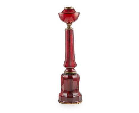 RUBY GLASS PARAFFIN LAMP BASE 19TH CENTURY of facetted mallet shape, with lacquered brass mounts(63cm high)Provenance: Proper