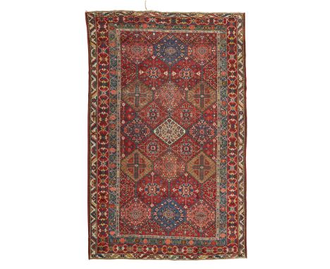 BAKHTIARI CARPET WEST PERSIA, LATE 19TH/EARLY 20TH CENTURY the red field with three columns of polychrome hexagonal medallion