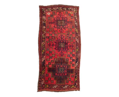 KYRGYZ CARPET KYRGYZSTAN, EARLY/MID 20TH CENTURY the red field with three indigo lattice rectangular medallions, within brown