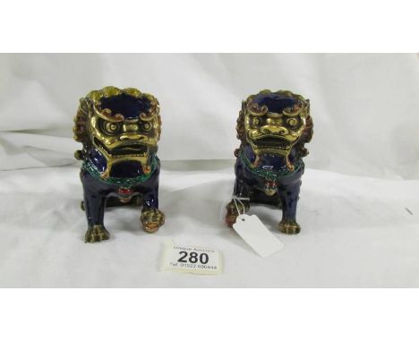 A quality pair of Chinese Foo Dogs, 20th Century Export, beautifully decorated in cobalt blue and 24ct gold enamel on brass. 