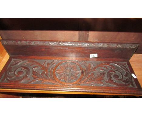 A carved oak wall shelf.