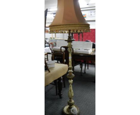 A wooden painted standard lamp with shade.