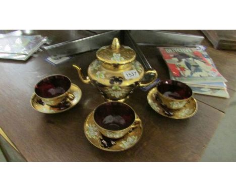 An Italian Venetian gilded ruby red part tea set with floral motif.