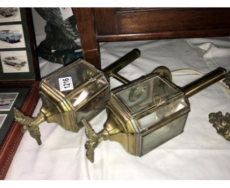 A pair of brass replica carriage lamp style exterior lights with eagle tops.