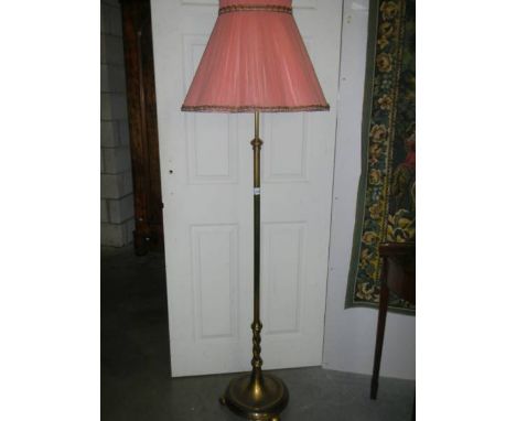 A brass standard lamp with shade.