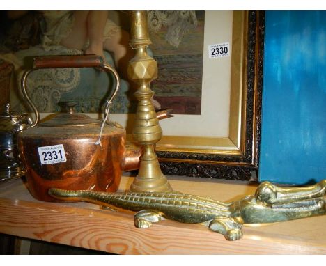 An oval copper kettle, a brass candlestick and a brass crocodile.