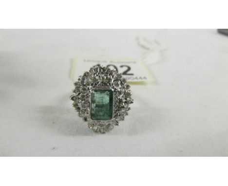 A 14ct white gold 1.75 emerald and 1.8 diamonds ring, size P.