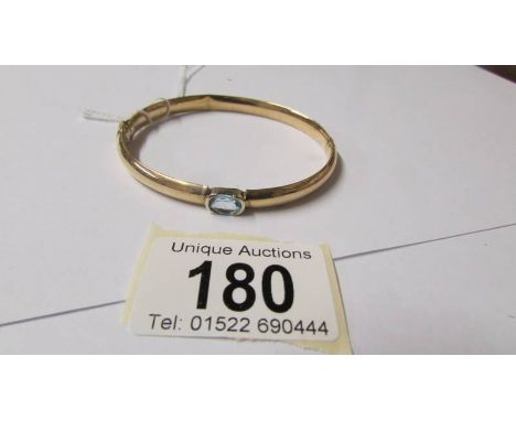 A 9ct gold and aquamarine bangle, 10 grams (some dints on inside). ****Condition report**** Postage to Mainland UK £10+VAT=£1