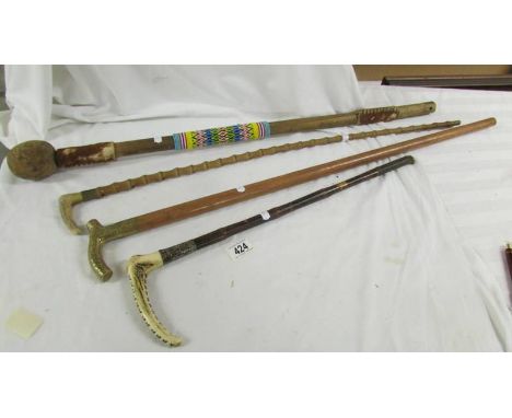 2 walking sticks. a riding crop and an Aboriginal walking stick.