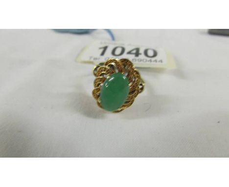 A 14ct gold jade ring in an oval design, size L.
