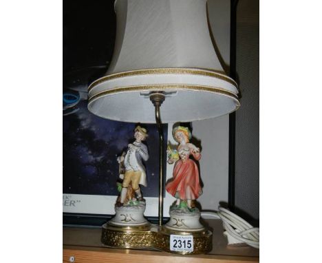 A good double porcelain figure table lamp on brass base, in good condition.