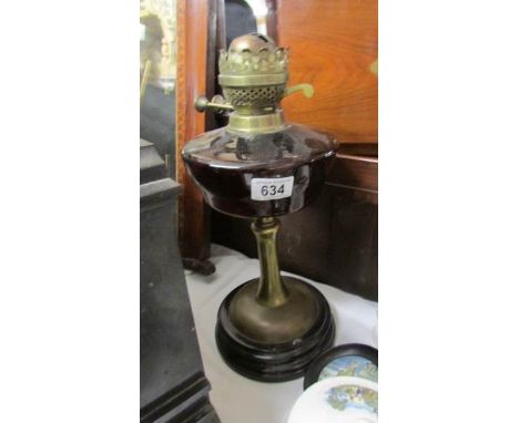 A Victorian oil lamp base with glass font and complete with burner.