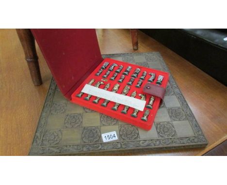 A cased metal Catholic and Arab chess set with decorative board. ****Condition report**** Board in good condition but dusty.C