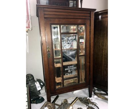 An Edwardian oak cabinet with bevelled mirror panels painted with milinary, Chicago advertising. ****Condition report**** Age