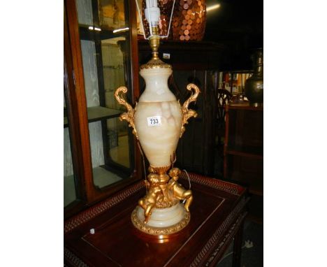 An alabaster and gilt table lamp surmounted cherubs.