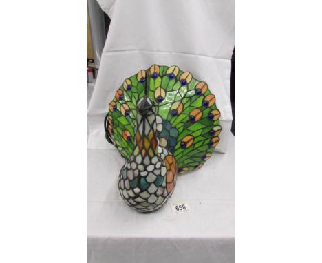 An unusual Tiffany style table lamp in the form of a peacock.