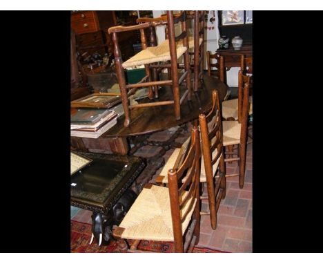 A large antique country gate-leg table on barley twist supports, together with a set of six ladder back chairs