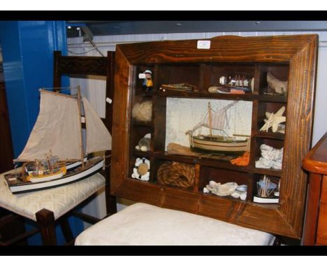 A wall mounted display cabinet containing maritime paraphernalia, together with two model dinghy's