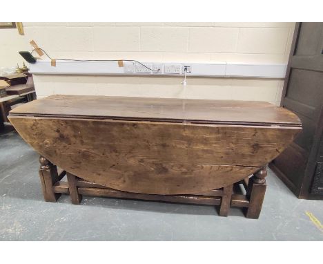 18th century style elm and oak gate-leg wake table with plank top, having single drawer beneath. Height 77cm, Width 198cm. Co
