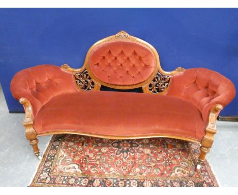 19th Century Victorian mahogany upholstered parlour sofa with button pad back, pierced fret scrolled arms, and raised on turn