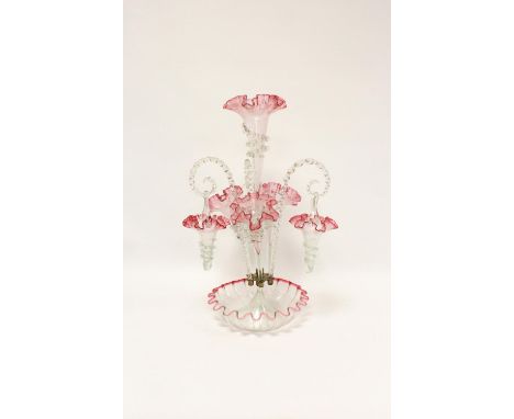 Edwardian cranberry and clear glass table epergne with four trumpets and three hanging baskets. Height 55cm.