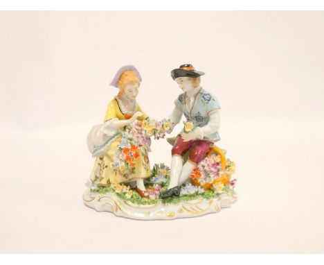 Sitzendorf figure of a rustic couple in 18th century dress, making flower sprays, 15cm wide.