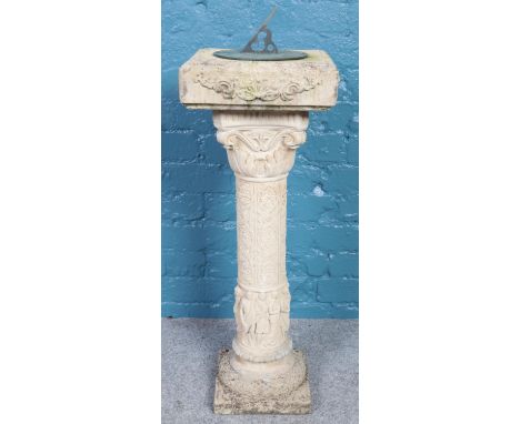 A cast concrete sundial. Decoration with figures to the column. (92cm)  