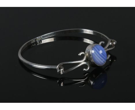 A silver bangle, set with blue stone, assayed London 1979.  