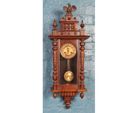 A mahogany Vienna wall clock, with turned spindles and finial depicting an eagle. In working order. Pendulum and key present.