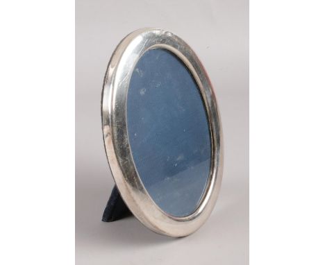 A silver oval photo, with easel back. Assayed for Sheffield, 1992 by Laurence R Watson &amp; Co. Height: 17cm.  