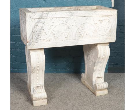 A large rectangular marble planter, on raised legs, decorated with vines and grapes. Width: 86cm, Depth: 40cm.  Small chip fr