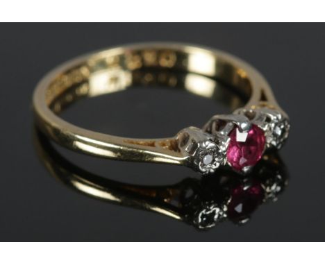 An 18ct Gold ruby and diamond three stone ring. Size K. Total weight: 2.04g.  