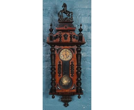 A carved mahogany Vienna wall clock. Pediment decorated with horse finial and carved mask.  