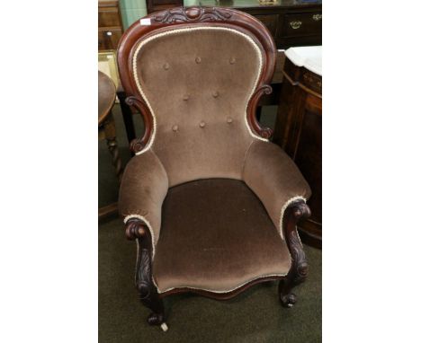 A Victorian carved mahogany framed button back armchair