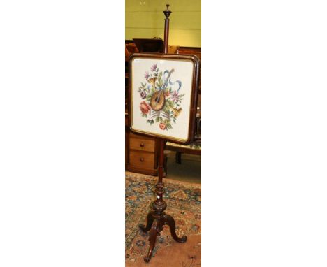 A Victorian mahogany pole screen on carved tripod support 