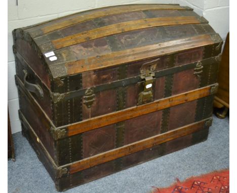 An iron and wooden bound dome topped trunk, with leather handles and lined interior 