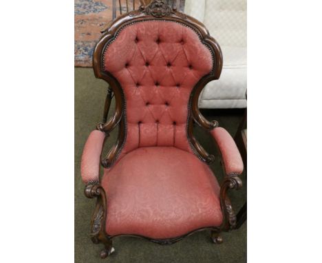 A Victorian carved mahogany framed button back open armchair