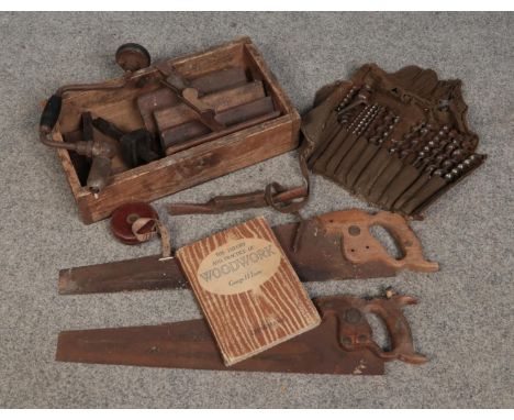 A box of vintage hand tools. Includes Spear and Jackson saw, drill bits, woodwork book etc.  